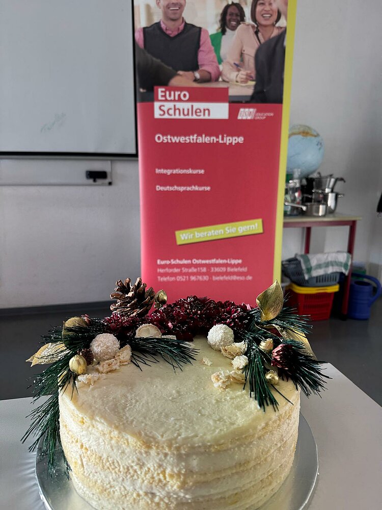 Ein weiße Torte mit verschiedenen Verzierungen.