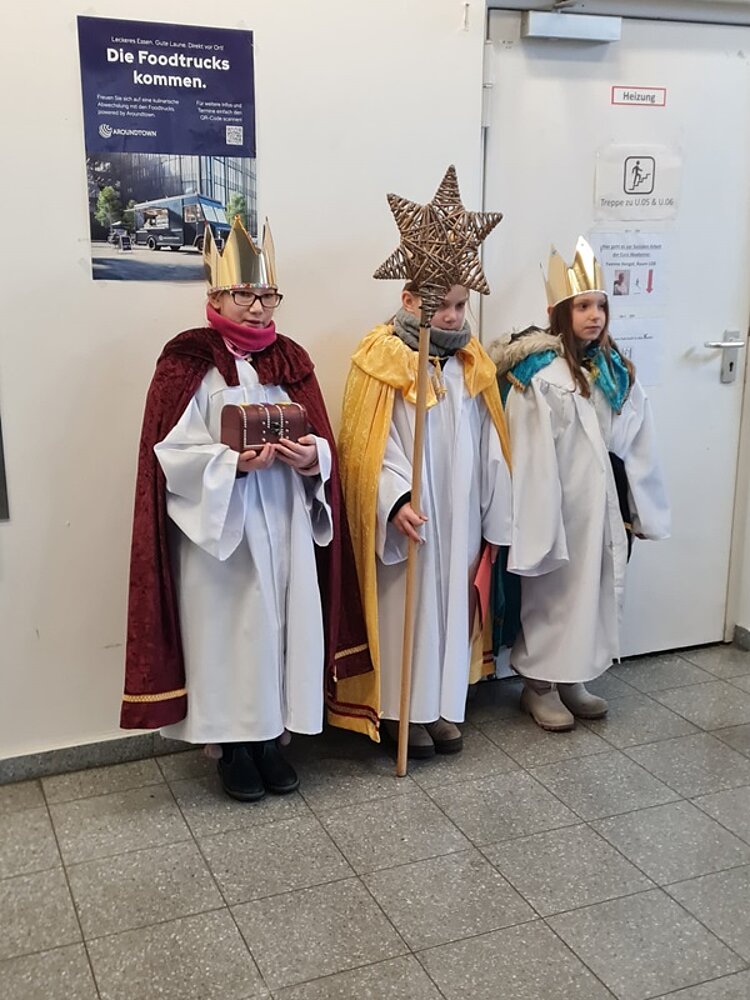 Die kleinen Sternsinger posieren zauberhaft verkleidet als Caspar, Melchior und Baltasar für ein Foto.